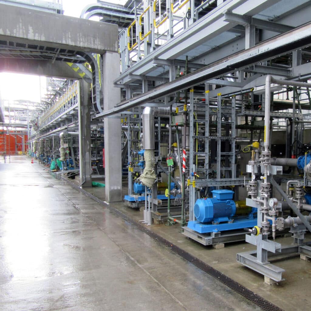 Industriële installatie met pijpleidingen tijdens een regenachtige Nederlandse dag.